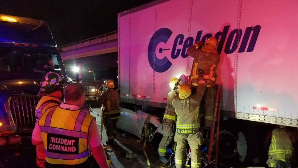 Firefighters work to rescue a person trapped under a tractor-trailer. (Image/Twitter: @AustinFireInfo)