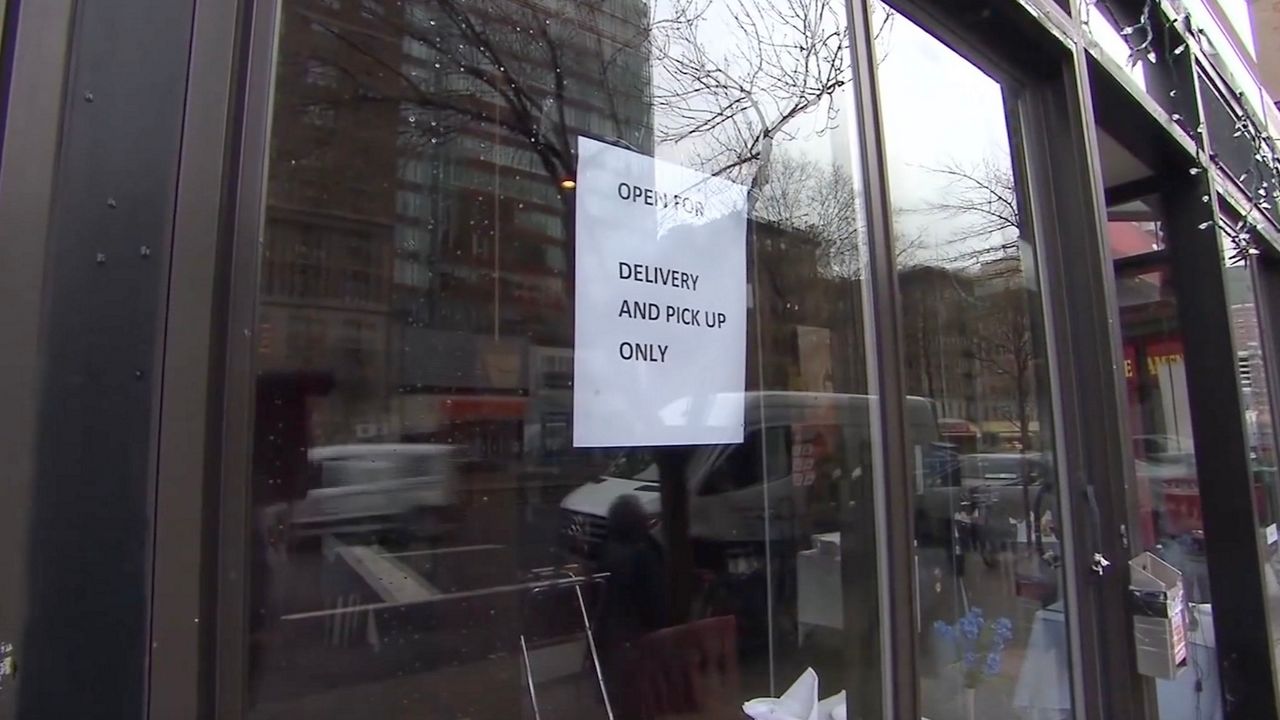 Storefront window with a sign that says Open for delivery and pick-up only