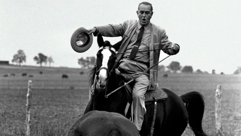 FILE - In the Nov. 4, 1964, file photo, President Lyndon Johnson proves he’s a pretty good cowhand as he puts his horse, Lady B, through the paces with a Hereford yearling on his LBJ Ranch near Stonewall, Texas. The LBJ Ranch is where Johnson was born, lived and died. It influenced his views on poverty and inequality. It served as the Texas White House. (AP Photo/Bill Hudson, File)