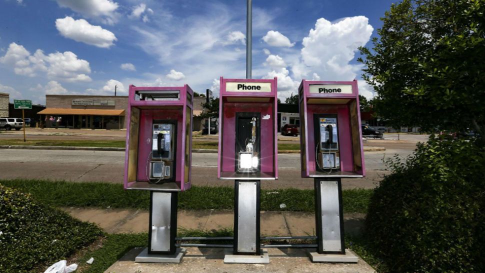 This Friday, July 13, 2018 photo shows pay phones in front of a Gulf gas station on Hillcroft Street in Houston. A Houston-area man must serve 18 months in federal prison and repay $2.4 million for what prosecutors call a pay phone scam since 2005. David Grudzinski of Friendswood was sentenced Friday in Houston. Investigators say Grudzinski owned about 450 pay phones in the Houston area. Grudzinski acknowledged a scheme to unlawfully obtain payments from the owners of toll-free numbers for calls to his pay phones. (Elizabeth Conley/Houston Chronicle via AP)