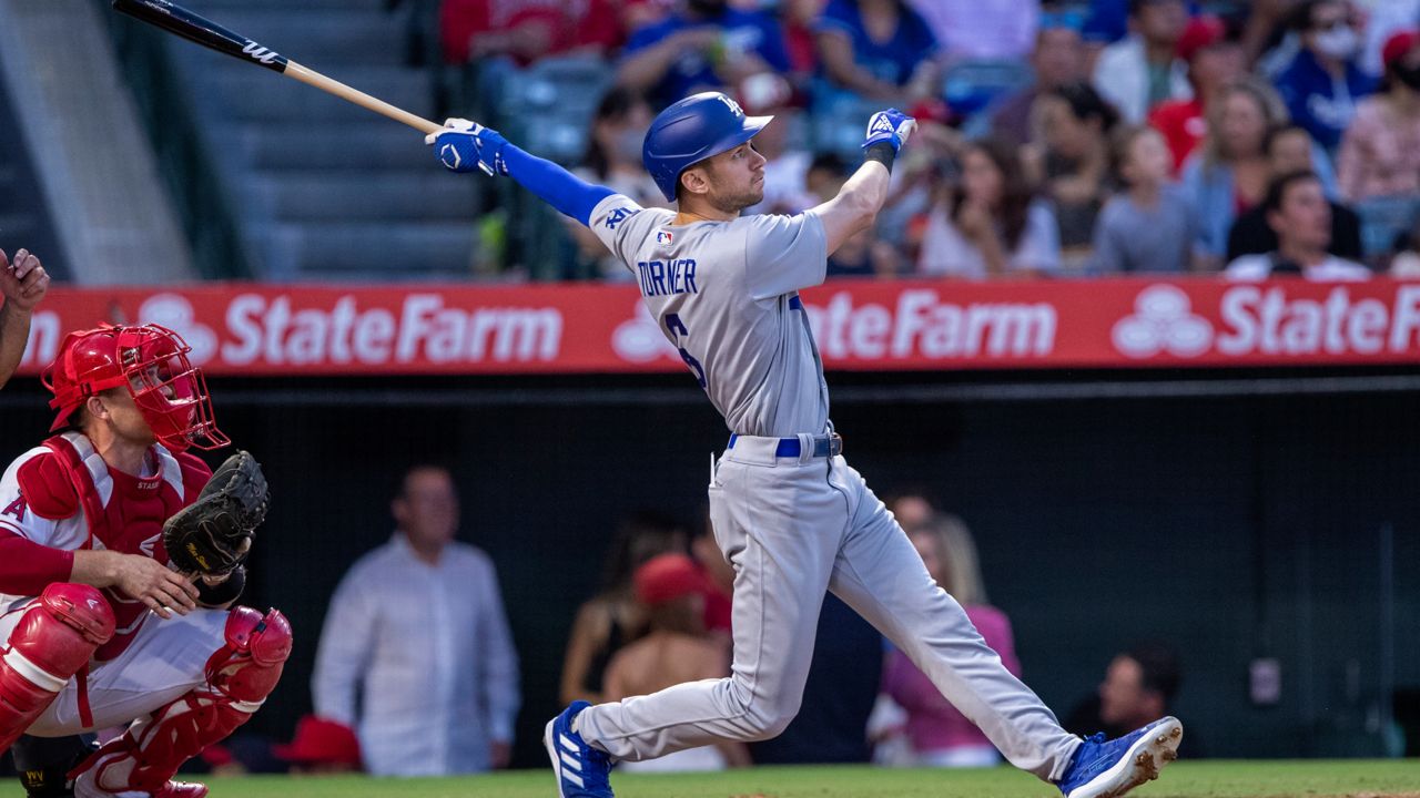 Los Angeles Dodgers' Trea Turner watches his two-run home run next to Los Angeles Angels catcher Max Stassi during the third inning of a baseball game in Anaheim, Calif., Saturday, July 16, 2022. (AP Photo/Alex Gallardo)