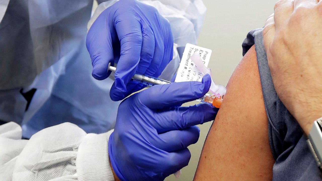 Person receiving a shot in the first-stage safety study clinical trial of a potential vaccine for COVID-19. (AP Photo)