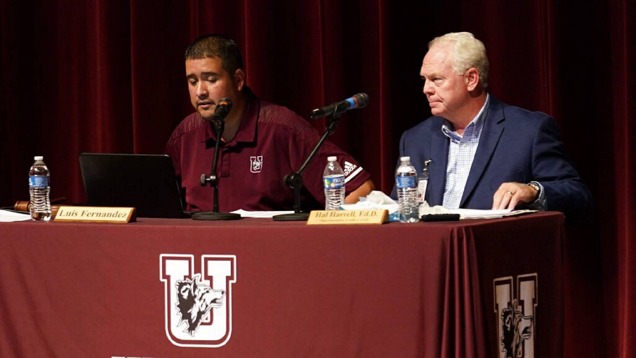 Dr. Hal Harrell, right, and Uvalde Consolidated Independent School District Board Trustee president Luis Fernandez, left, listen to comments from parents and residents during a special meeting to address concerns over last month's shootings at Robb Elementary School, Monday, July 18, 2022, in Uvalde, Texas. (AP Photo/Eric Gay)