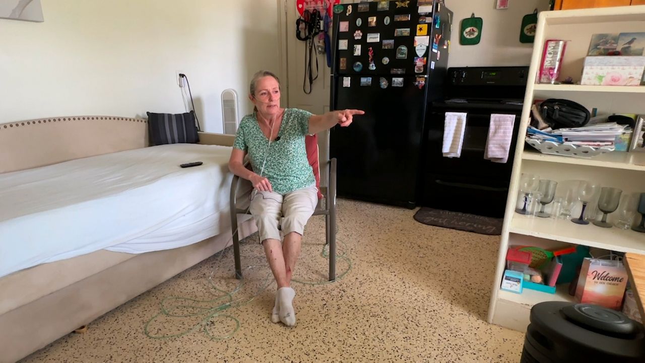 Kelly Murphy in her damaged living room. (Spectrum Bay News 9/Saundra Weathers)