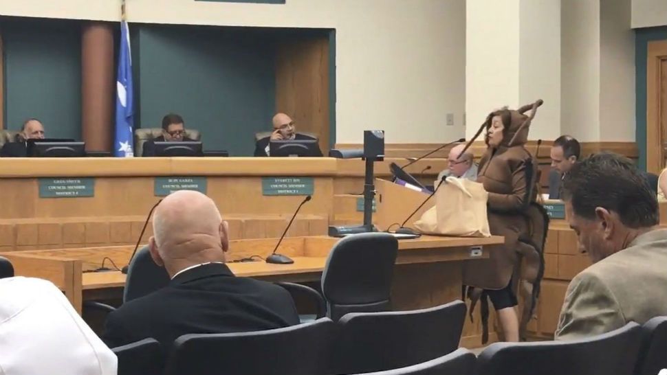 Corpus Christi resident Patricia Polastri, dressed as a cockroach, speaks Tuesday, July 17, 2018, about her concern for the growing number of rodents and insects that she claims have been brought by newly planted palm trees. The Texas A&M University-Kingsville professor brought a bag of dead cockroaches to a City Council meeting last month to complain about the vegetation planted along Ocean Drive. She said residents' safety is at risk by cockroaches and other rodents attracted to the street's palm trees and bushes. (Julie Garcia/Corpus Christi Caller-Times via AP)