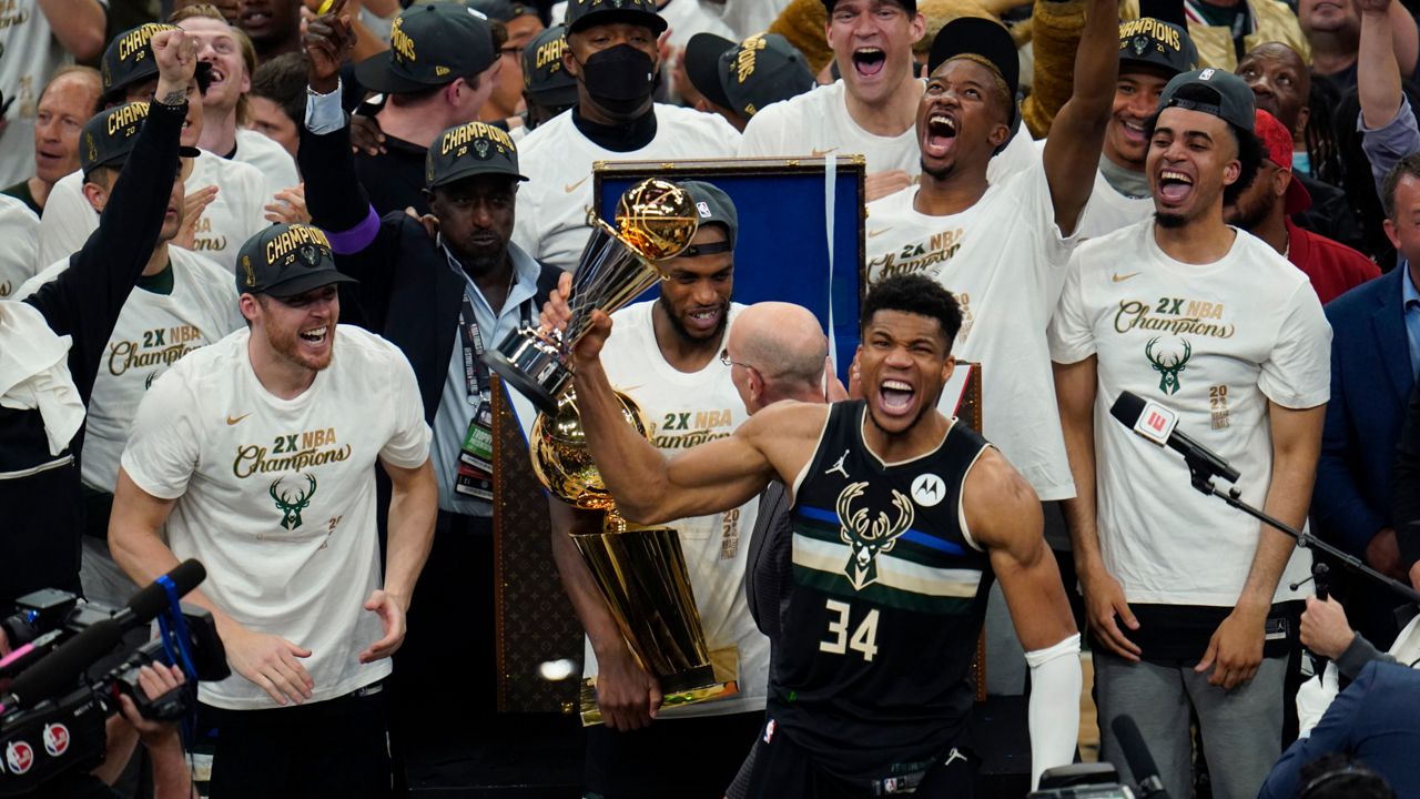 Milwaukee Bucks forward Giannis Antetokounmpo (34) holds up the MVP trophy after defeating the Phoenix Suns in Game 6 of basketball's NBA Finals in Milwaukee, Tuesday, July 20, 2021. (AP Photo/Paul Sancya)