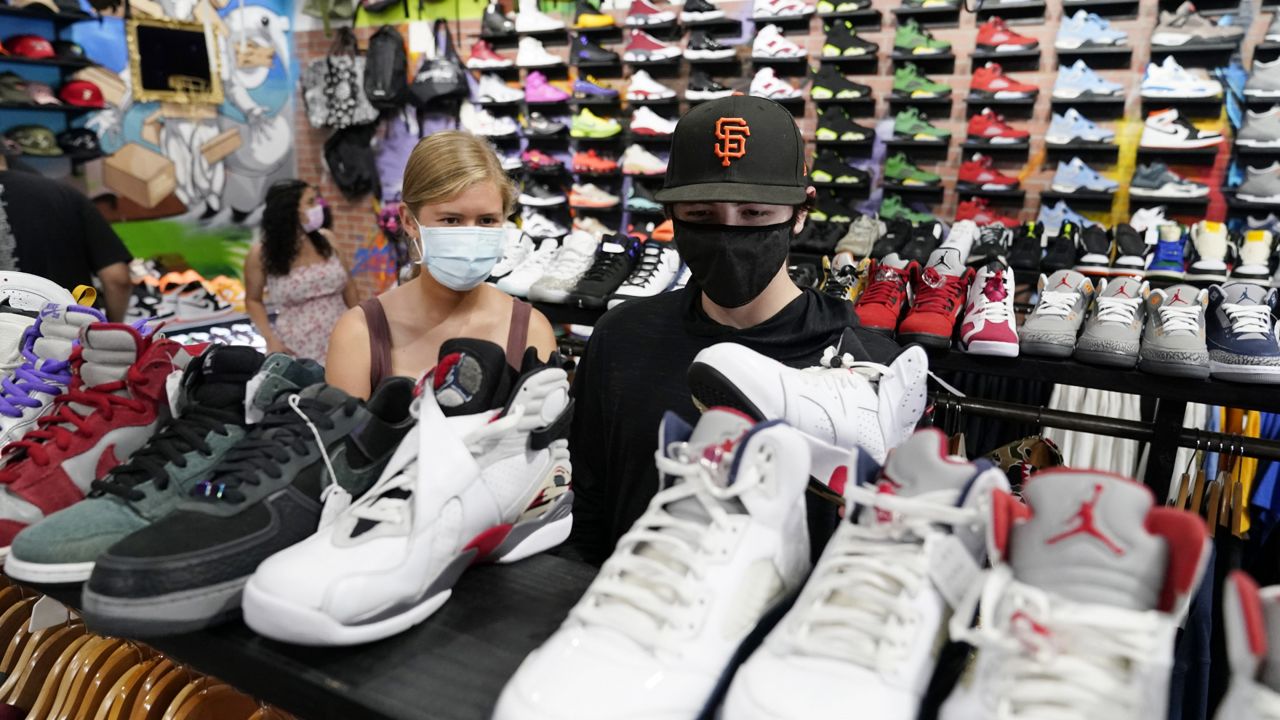 Shoppers wear masks inside of The Cool store Monday, July 19, 2021, in the Fairfax district of Los Angeles. (AP Photo/Marcio Jose Sanchez)