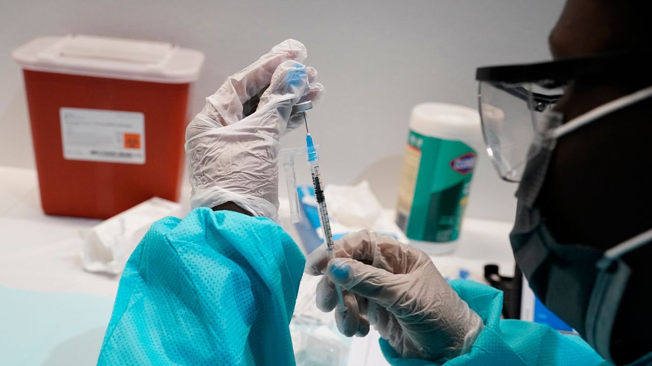 A health care worker fills a syringe with the Pfizer-BioNTech COVID-19 vaccine. (AP Photo, File)