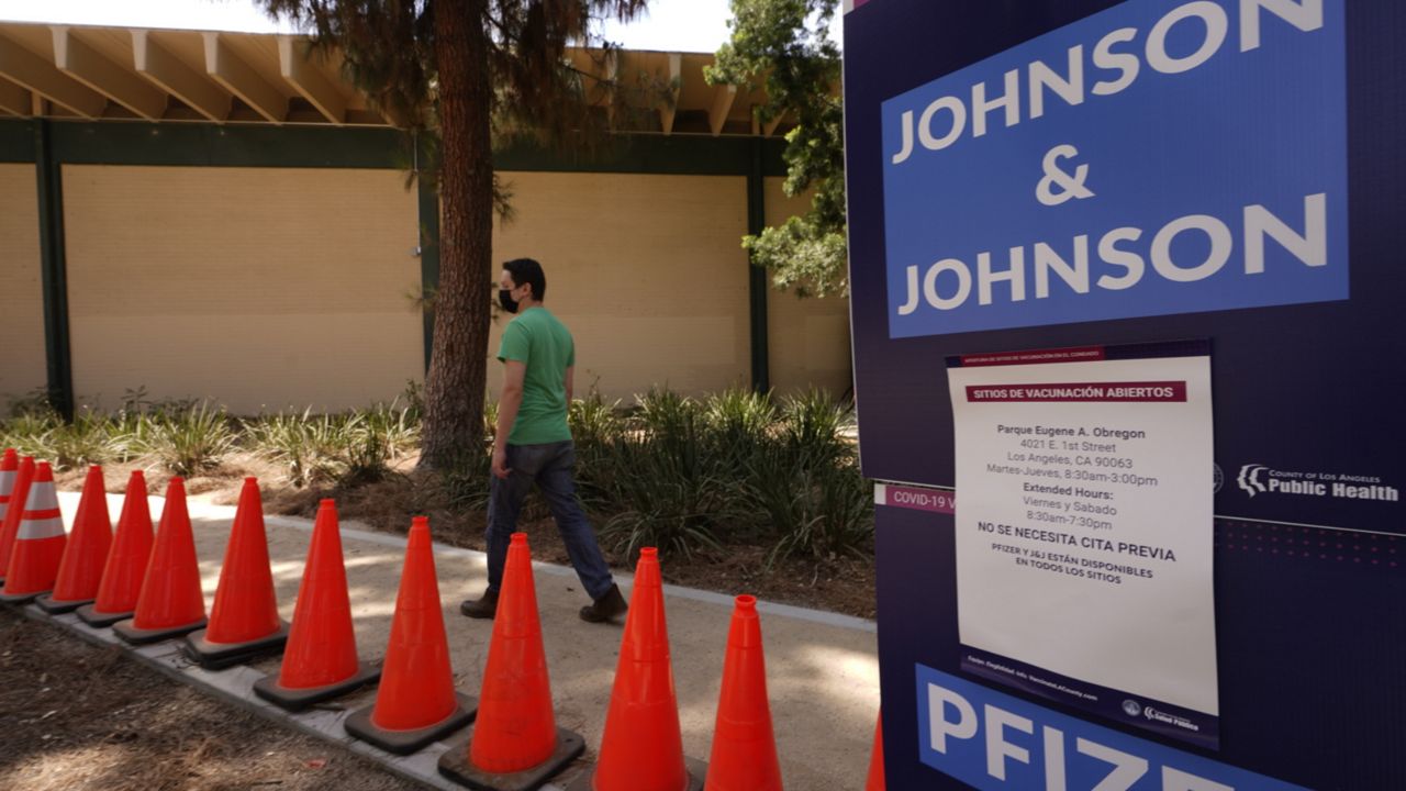 Carlos Arrendondo arrives for his appointment to get vaccinated, as banners advertise the availability of the Johnson & Johnson and Pfizer COVID-19 vaccines at a county-run vaccination site at the Eugene A. Obregon Park in Los Angeles Thursday, July 22, 2021. (AP Photo/Damian Dovarganes)