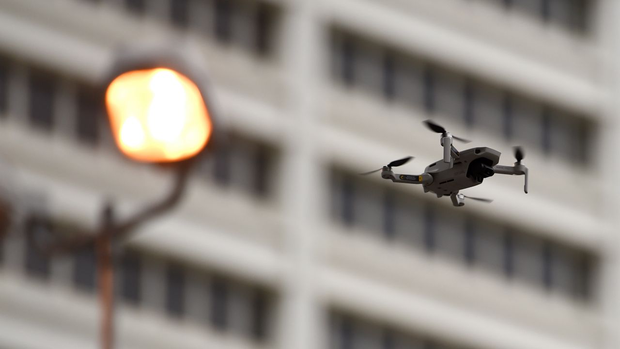 In this file photo from Friday, June 5, 2020, a law enforcement drone flies over demonstrators protesting in Atlanta. (AP Photo/Mike Stewart)