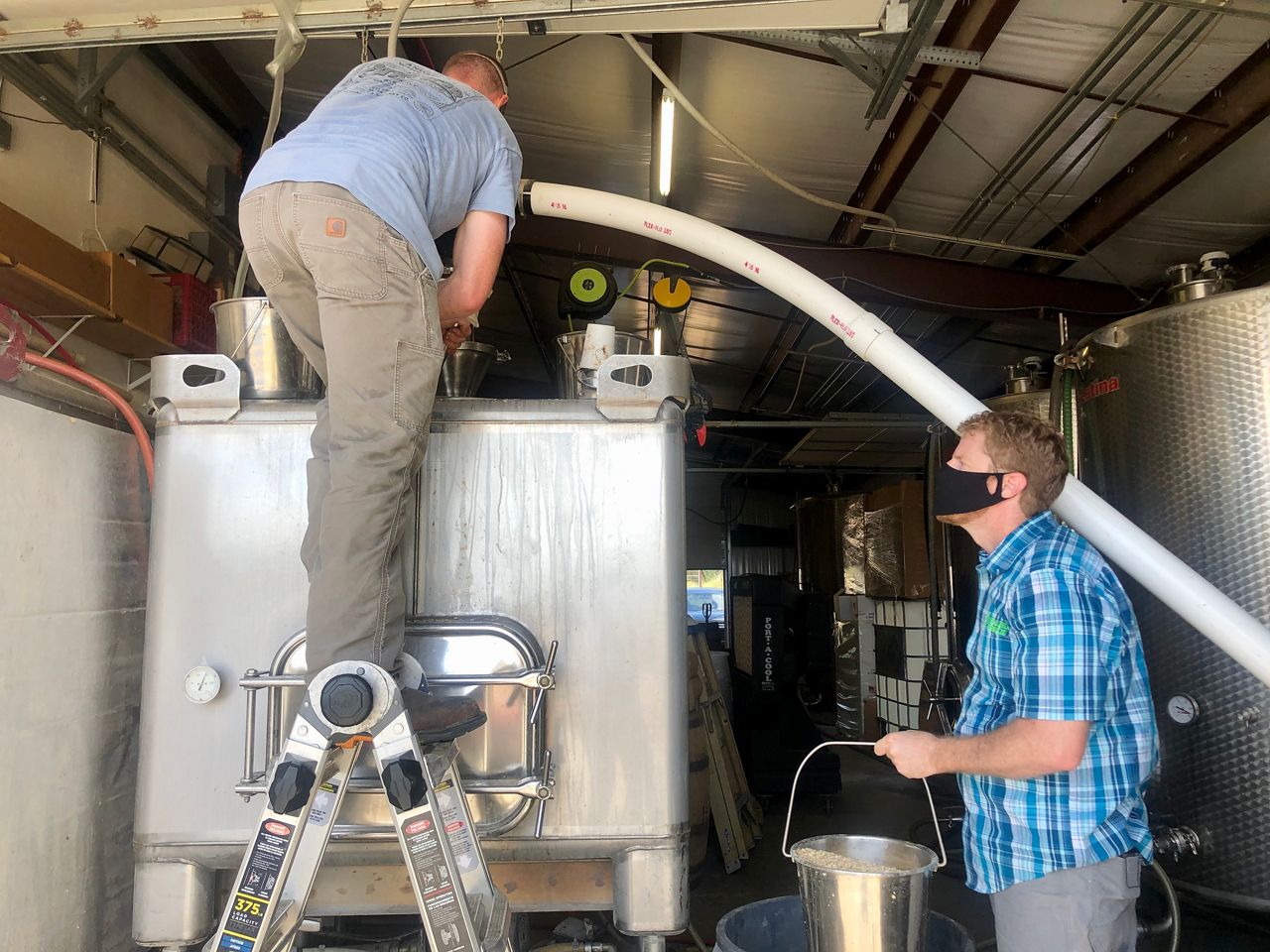 Andalusia Whiskey owner Ty Phelps (right) helps with the mushing and malting process at his distillery (Reena Diamante/Spectrum News)