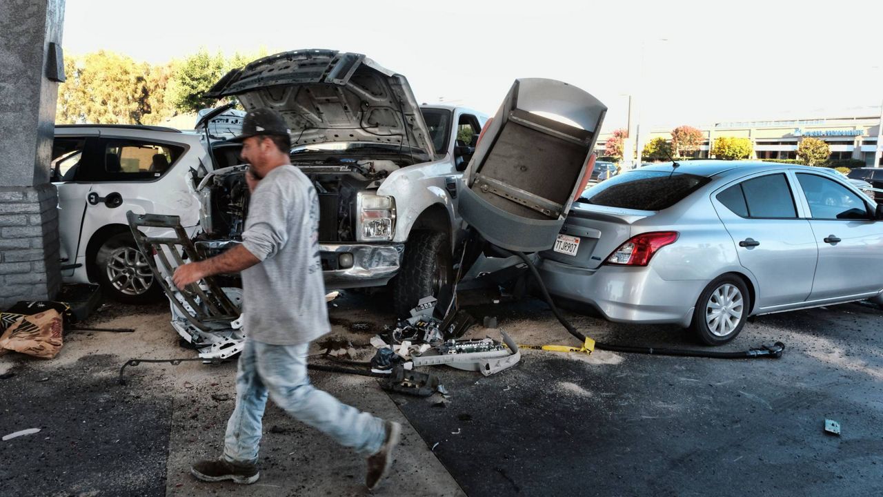 Police investigate a car accident at a gas station in the Panorama City section of Los Angeles on Tuesday. (AP Photo/Richard Vogel)