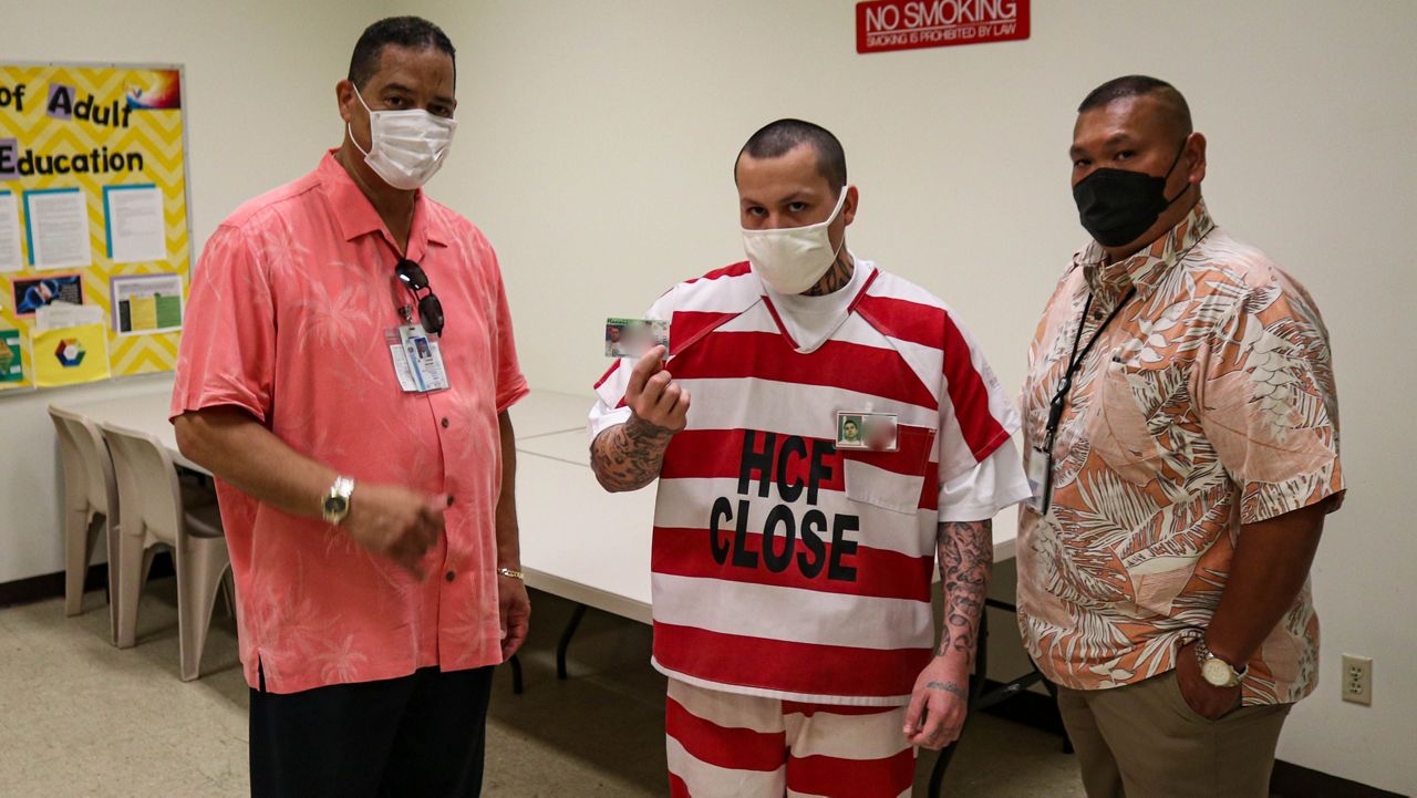 Halawa Correctional Facility inmate Ronald Pszyk, pictured with Public Safety Department Deputy Director for Corrections Tommy Johnson (left) and Halawa Correctional Facility warden Lyle Antonio, displays his REAL State ID. (Department of Public Safety)