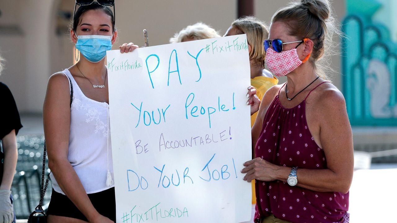 People protest problems with the unemployment benefits system at Lake Eola in Orlando in June. (AP)