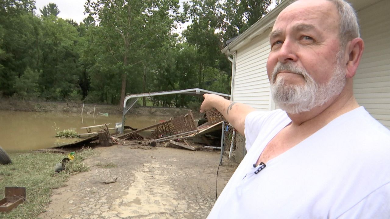 Wayne Shields pointing out flood damage