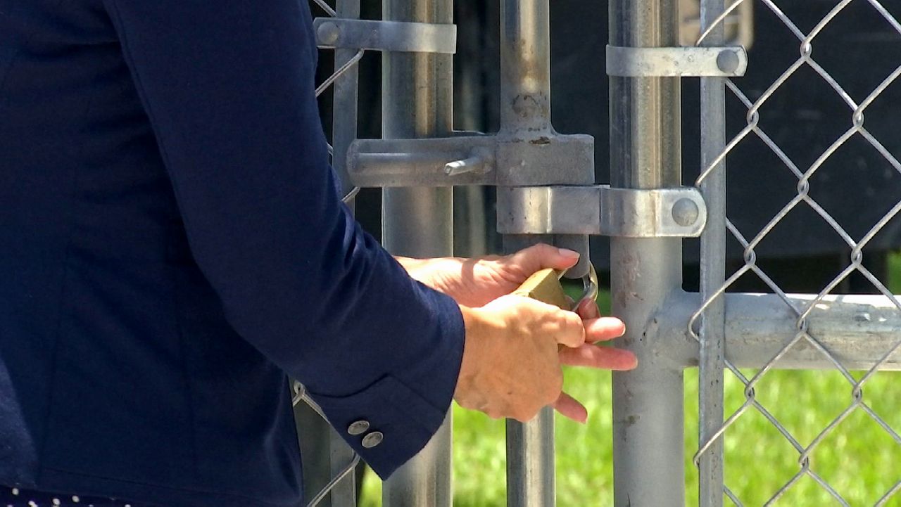 Officials from Brevard Public Schools showed up for the ceremonial locking of the last fence in the district with a golden padlock symbolizing the completion of the single-point-of-entry project. (Spectrum News image)