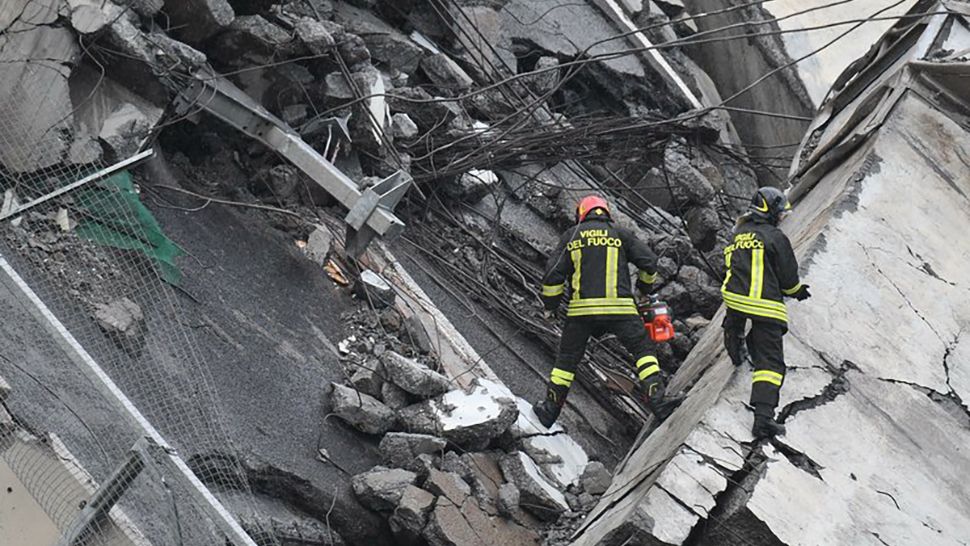 Rescues work among the rubble of the collapsed Morandi highway bridge in Genoa, northern Italy, Tuesday, Aug. 14, 2018. A large section of the bridge collapsed over an industrial area in the Italian city of Genova during a sudden and violent storm, leaving vehicles crushed in rubble below. (Luca Zennaro/ANSA via AP)