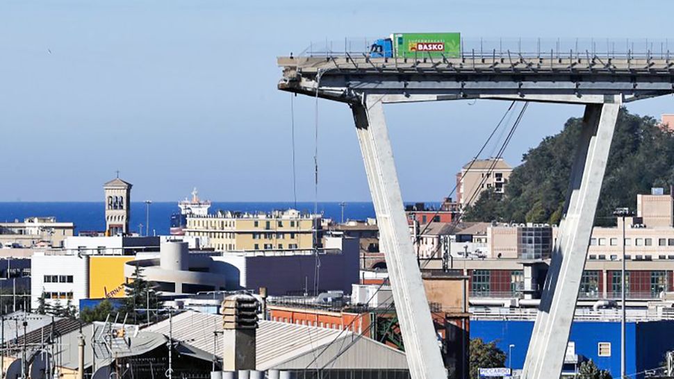 A view of the Morandi highway bridge that collapsed in Genoa, northern Italy, Wednesday, Aug. 15, 2018. A large section of the bridge collapsed over an industrial area in the Italian city of Genova during a sudden and violent storm, leaving vehicles crushed in rubble below. (AP Photo/Antonio Calanni)