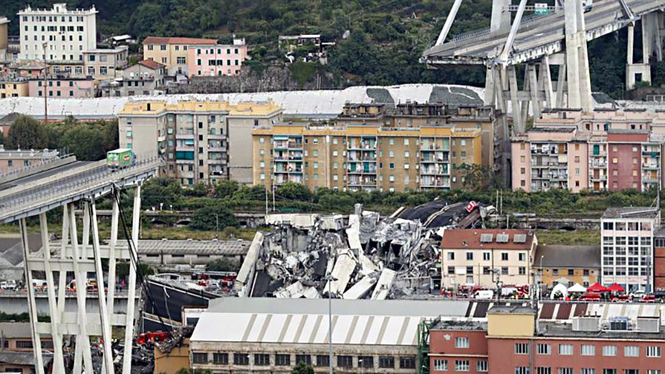 Cars are blocked on the Morandi highway bridge after a section of it collapsed, in Genoa, northern Italy, Tuesday, Aug. 14, 2018. A large section of the bridge collapsed over an industrial area in the Italian city of Genova during a sudden and violent storm, leaving vehicles crushed in rubble below. (AP Photo/Antonio Calanni)
