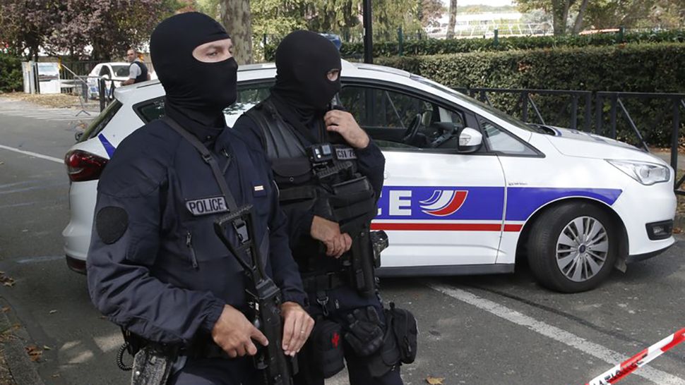 French hooded police officers cordon off the area after a knife attack Thursday, Aug. 23, 2018 in Trappes, west of Paris. A man flagged by French authorities as a suspected radical killed his mother and sister and seriously injured another woman in a knife attack Thursday that was quickly claimed by the Islamic State group. (AP Photo/Michel Euler)