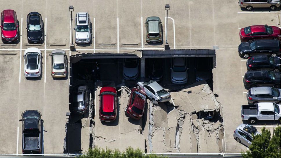 Emergency crews respond to a collapsed parking garage in Irving, Texas, Tuesday, July 31, 2018. A portion of a suburban Dallas parking garage has collapsed, sending vehicles and rubble onto others below, but authorities say there are no apparent injuries. (Ashley Landis/The Dallas Morning News via AP)