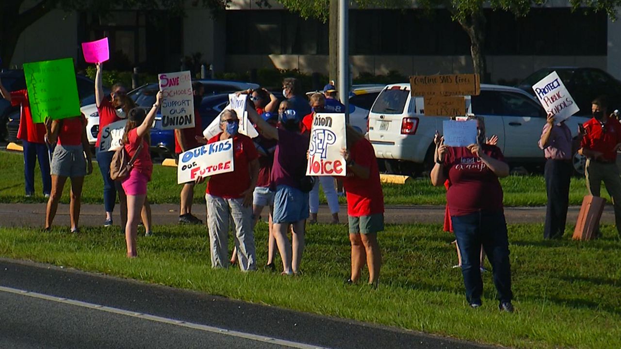 More than 50 teachers and their supporters protested outside Tuesday's School Board meeting. They are calling on the district to go all virtual until the number of COVID-19 cases goes down. (Laurie Davison/Spectrum Bay News 9)
