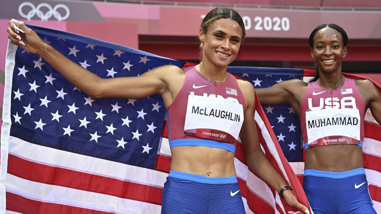 Sydney Mclaughlin, left, and Dalilah Muhammad, both of the United States, celebrate after finishing first and second respectively in the women's 400-meter hurdles during the 2020 Summer Olympics on Wednesday, Aug. 4, 2021, in Tokyo, Japan. (Andrej Isakovic/Pool Photo via AP)