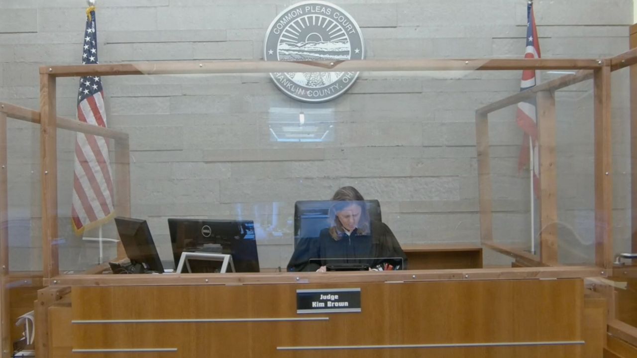 Judge Kim Brown sitting in court behind a glass barrier