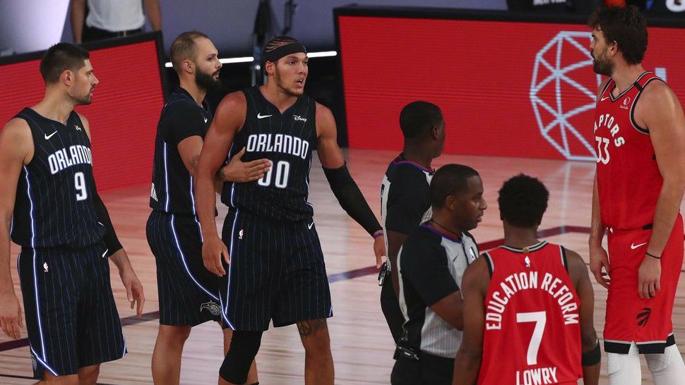 Orlando Magic forward Aaron Gordon (00) is held back by guard Evan Fournier (10) after getting fouled by Toronto Raptors guard Kyle Lowry (7) in the second half of an NBA basketball game Wednesday, Aug. 5, 2020, in Lake Buena Vista, Fla. (Kim Klement/Pool Photo via AP)
