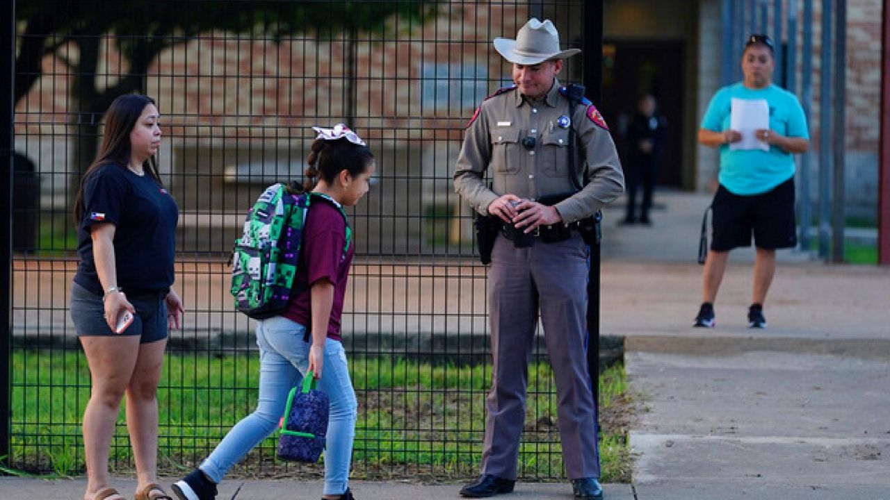 Students arrive at Uvalde Elementary, now protected by a fence and Texas State Troopers, for the first day of school, Tuesday, Sept. 6, 2022, in Uvalde. Students in Uvalde are returning to campuses for the first time since the shootings at Robb Elementary where two teachers and 19 students were killed. (AP Photo/Eric Gay)