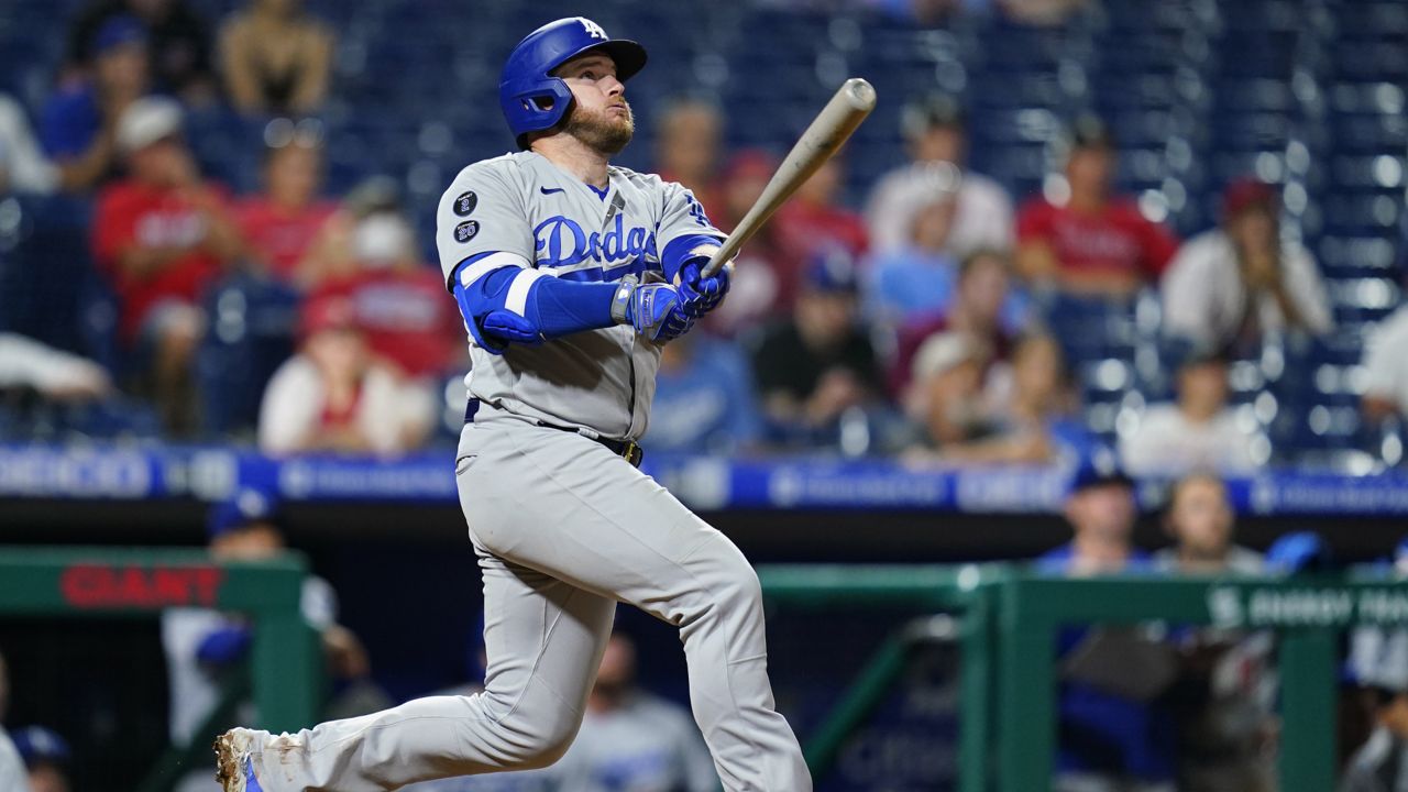 Los Angeles Dodgers' Max Muncy follows through after hitting a home run off Philadelphia Phillies relief pitcher Mauricio Llovera during the ninth inning of a baseball game, early Wednesday morning, Aug. 11, 2021, in Philadelphia. (AP Photo/Matt Slocum)