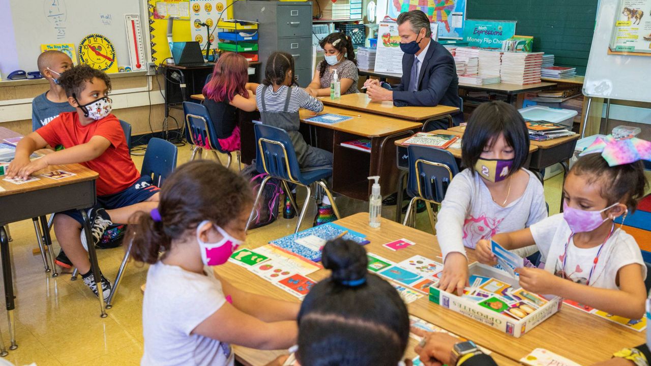 California Gov. Gavin Newsom sits with students of a second grade classroom at Carl B. Munck Elementary School, Aug. 11, 2021, in Oakland, Calif. (Santiago Mejia/San Francisco Chronicle via AP, Pool)