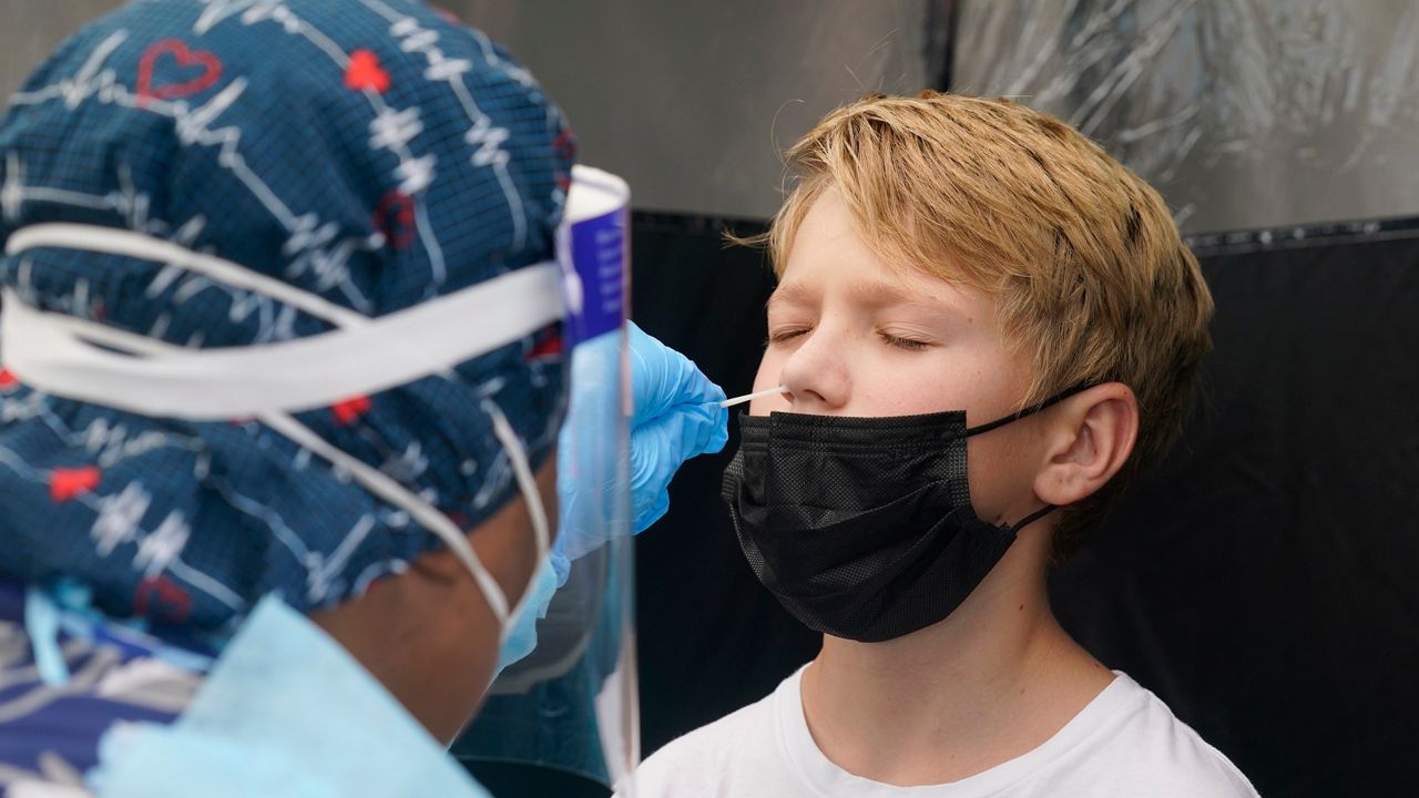 An 11-year-old boy gets a nasal swab to test for COVID-19