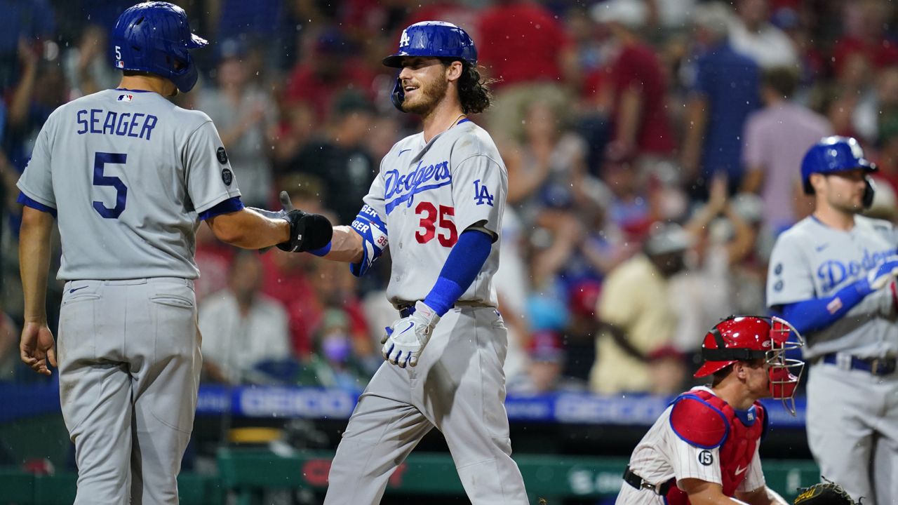 Los Angeles Dodgers' Cody Bellinger, center, celebrates with Corey Seager, left, after hitting a two-run home run of Philadelphia Phillies pitcher Kyle Gibson during the fourth inning of a baseball game, Wednesday, Aug. 11, 2021, in Philadelphia. (AP Photo/Matt Slocum)