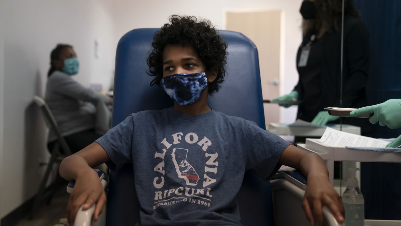 Marcus Morgan, 14, waits to receive his Pfizer COVID-19 vaccine at Families Together of Orange County in Tustin, Calif., Thursday, May 13, 2021. (AP Photo/Jae C. Hong)