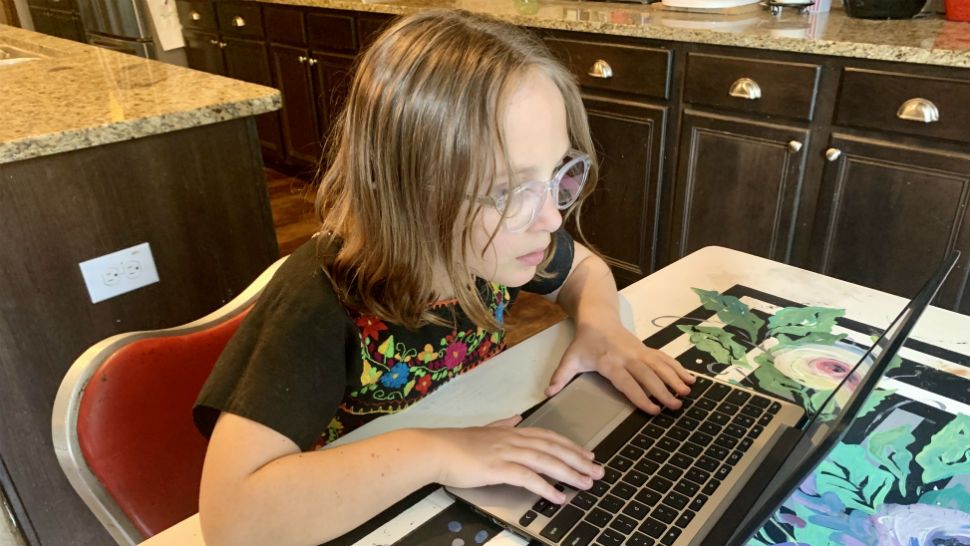 Cambria Johnston sits at her laptop. (Sarah Duran/Spectrum News)
