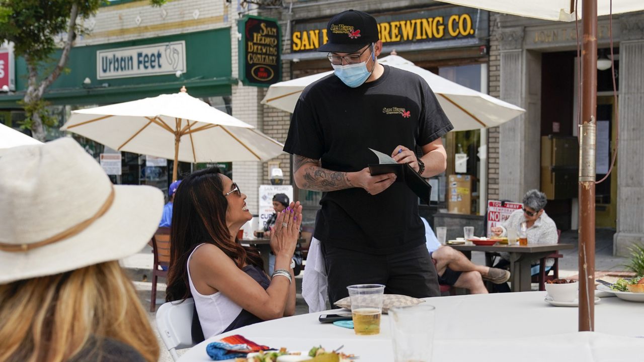 Dana Brown reacts as she orders food from Daryn Feenstra outside of San Pedro Brewing Company, Friday, May 29, 2020, in the San Pedro area of Los Angeles. (Ashley Landis/AP)