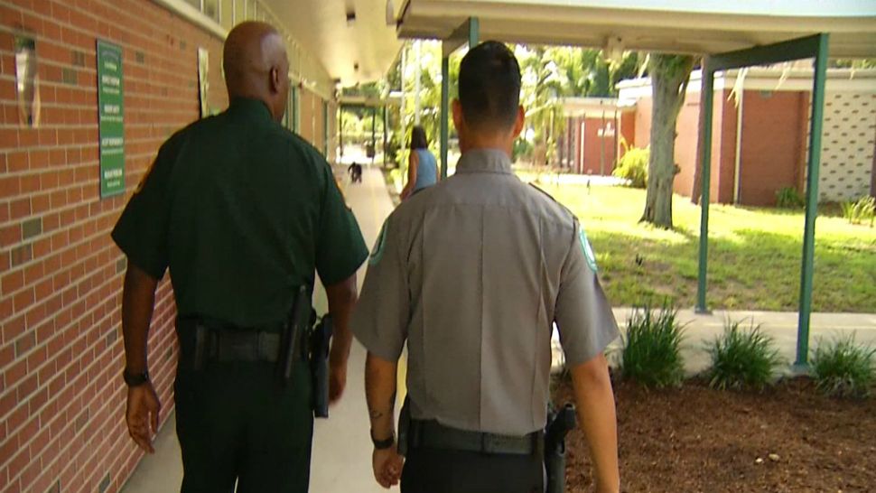Polk County Sheriff's Capt. Mike Wiggins walks with a school safety guardian during the first day of school Monday, Aug. 13, 2018. (Rick Elmhorst, Spectrum News)