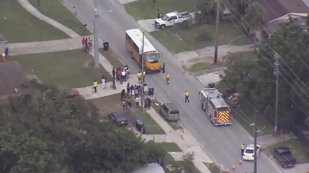 Students wait to be checked out for injuries after a bus collided with a pickup truck Tuesday. (Sky 13)