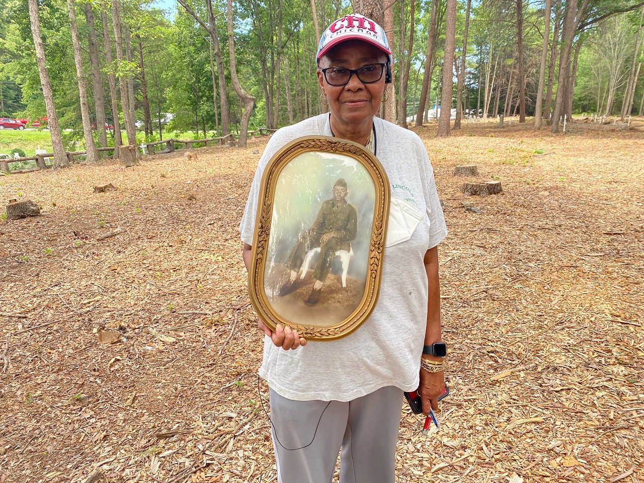 Wanda Cates at the cemetery with a picture of her late father. (Photo: Vanessa Leon)