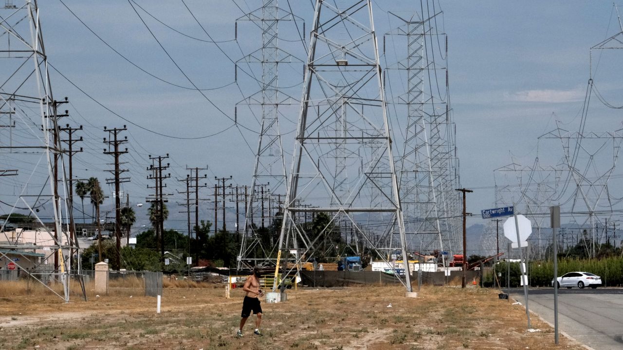 A jogger runs in extreme heat under high tension electrical lines in the North Hollywood section of Los Angeles on Saturday, Aug. 15, 2020. California has ordered rolling power outages for the first time since 2001 as a statewide heat wave strained its electrical system. (Richard Vogel/AP)