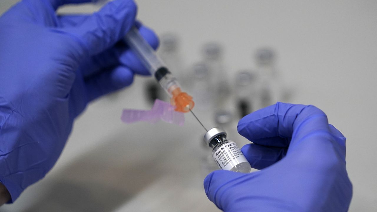 A pharmacy technician loads a syringe with Pfizer's COVID-19 vaccine, Tuesday, March 2, 2021, at a mass vaccination site at the Portland Expo in Portland, Maine. U.S. (AP Photo/Robert F. Bukaty)