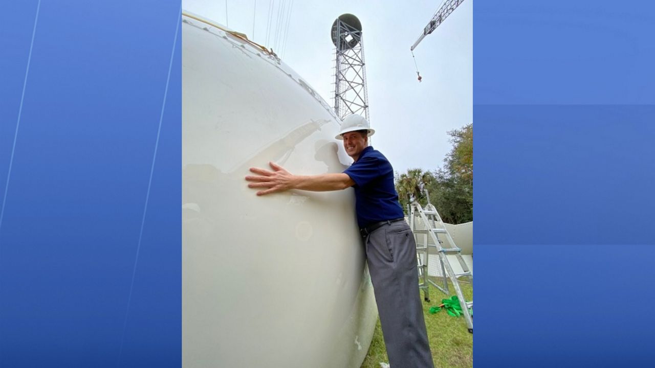 Spectrum News 13 Chief Meteorologist Bryan Karrick poses with Klystron 13's new radome in Cocoa.