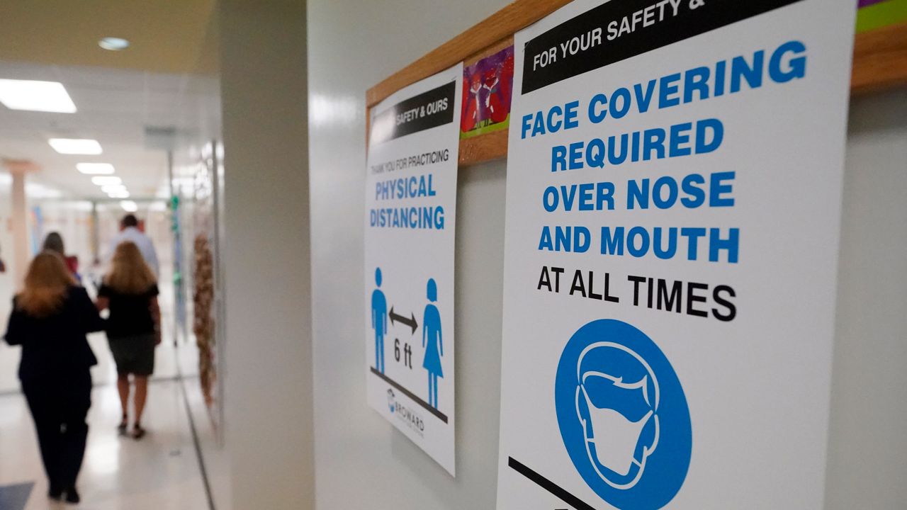 Signs in a hallway remind students to wear masks and distance themselves at Fox Trail Elementary School, Friday, Oct. 9, 2020, in Broward County, Fla. (File/AP)