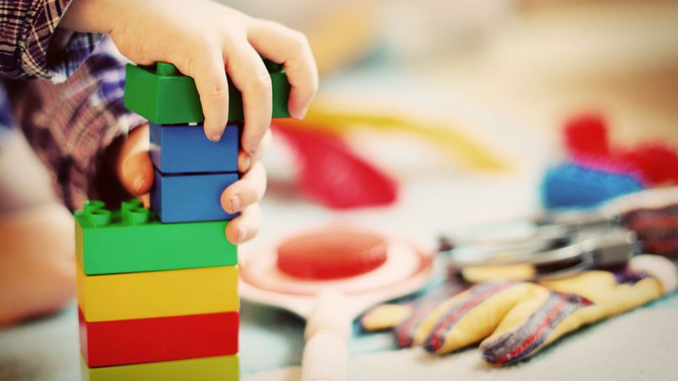 A child stacks duplos.