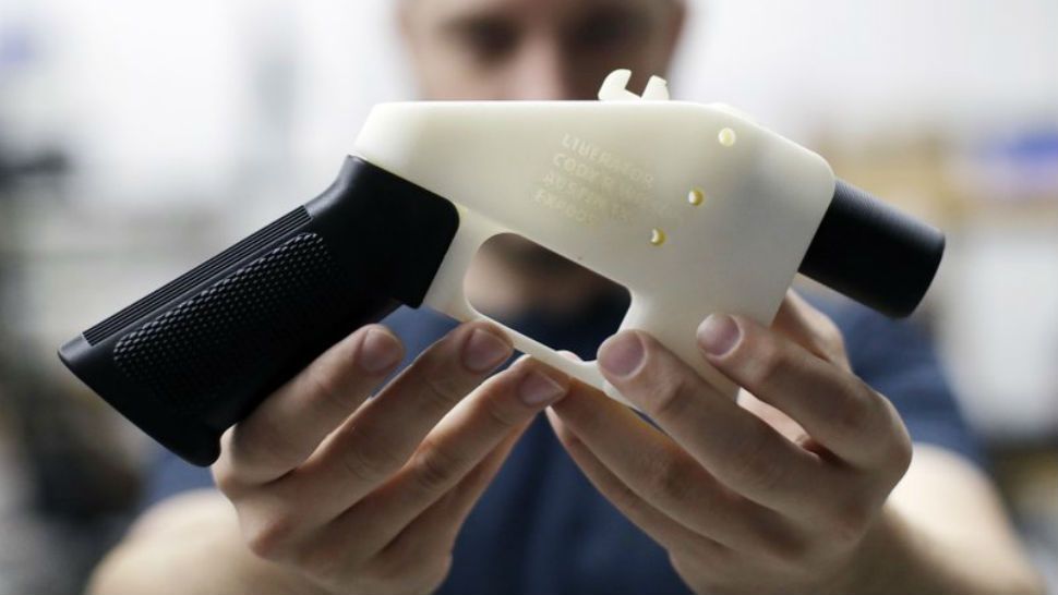 FILE - In this Aug. 1, 2018, file photo, Cody Wilson, with Defense Distributed, holds a 3D-printed gun called the Liberator at his shop in Austin, Texas. A federal judge in Seattle is scheduled to hear arguments Tuesday, Aug. 21, 2018, on whether to block a settlement the U.S. State Department reached with a company that wants to post blueprints for printing 3D weapons on the internet. (AP Photo/Eric Gay)