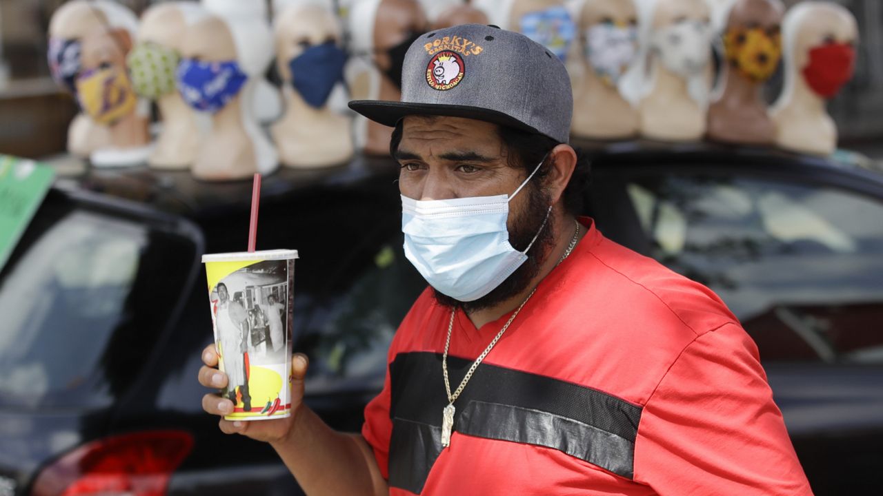 A man walks past a row of face masks for sale amid the coronavirus pandemic Monday, June 29, 2020, in Los Angeles. (Marcio Jose Sanchez/AP)