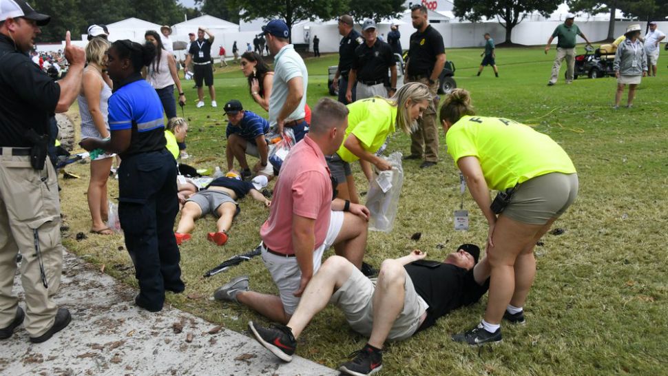 Spectators are tended to after a lightning strike on the course left several injured during a weather delay in the third round of the Tour Championship golf tournament Saturday, Aug. 24, 2019, in Atlanta. (AP Photo/John Amis)