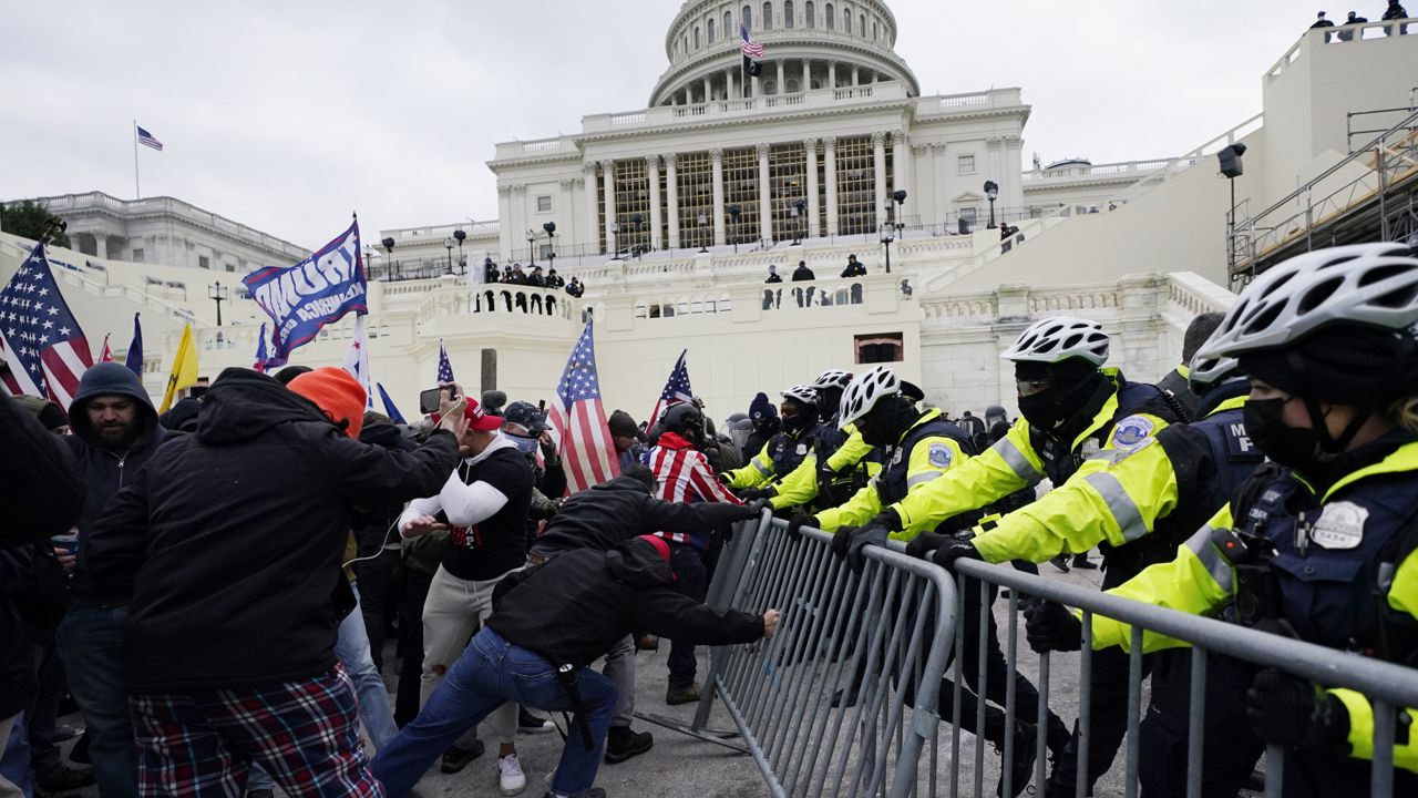 Rioters try to break through a police barrier at the Capitol in Washington on Jan. 6, 2021. (AP Photo/Julio Cortez)