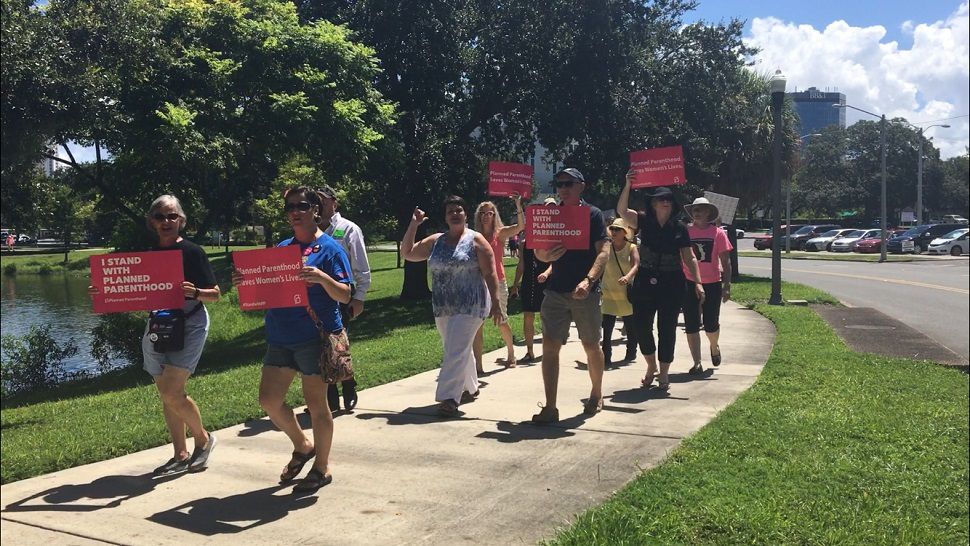To honor Women's Equality Day, women and men gathered for a service at Unitarian Universalist Church of St. Petersburg. Then they marched around the area, holding signs, and chanting. (Jorja Roman, staff)
